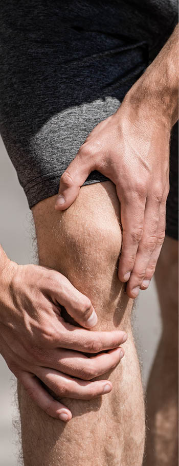 partial view of sportsman with knee pain on street
